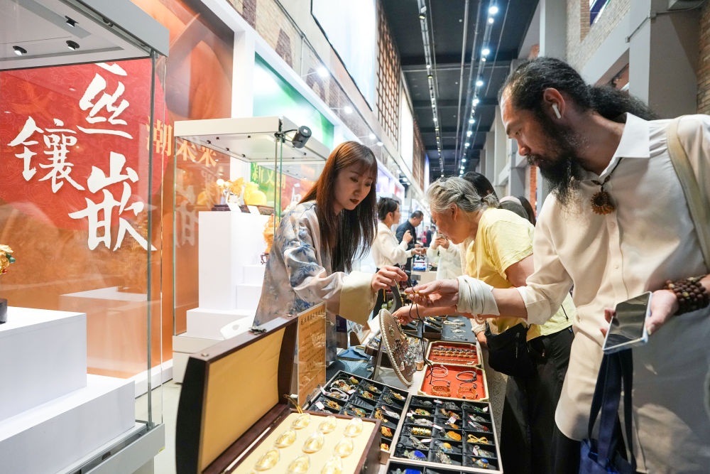 2026年5月15日,市民游客在北京朝阳公园的首届中国新文创市集暨潮玩游园会的花丝镶嵌大师工坊参观选购。