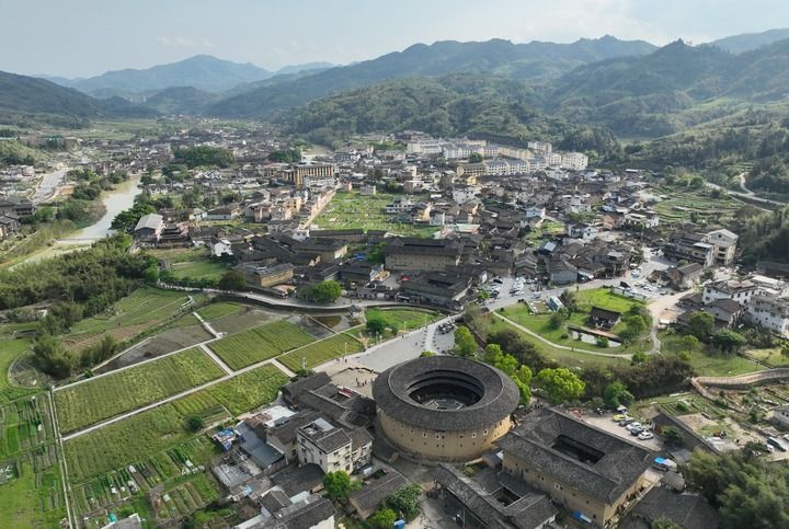 2026年4月9日，游客在福建省漳州市南靖县梅林镇参观怀远楼、和贵楼、长教溪等景点（无人机照片）。